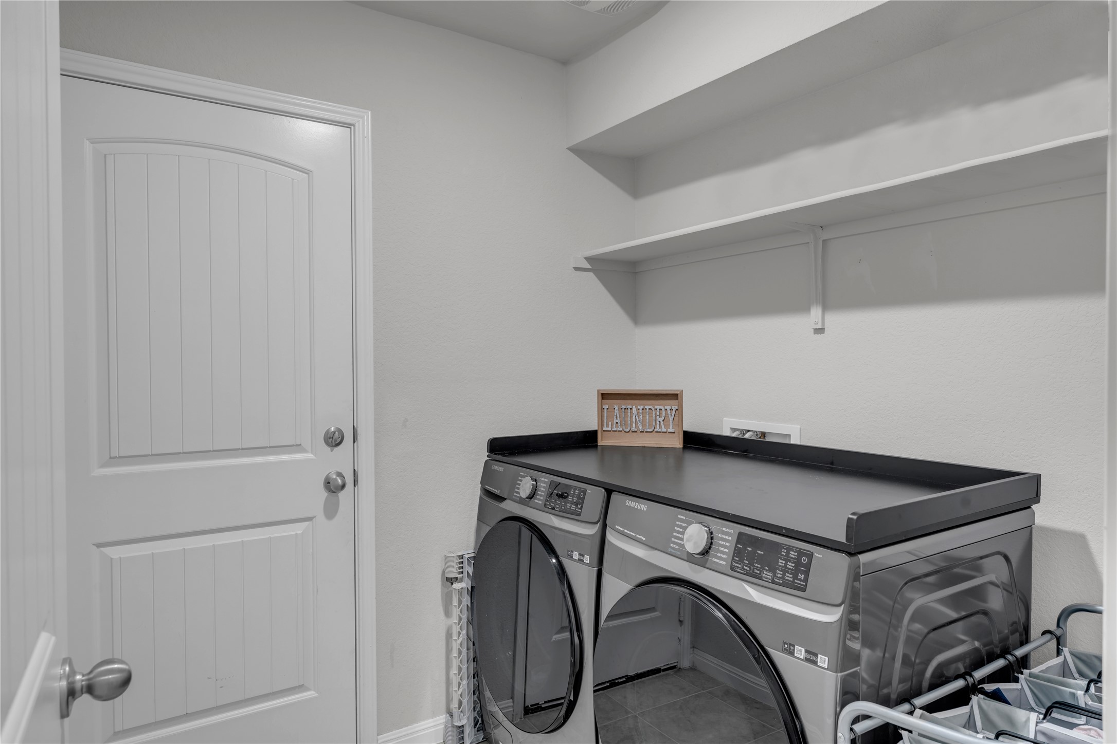132 Cinnamon Loop Burnet, TX 78611 - Photo 22 of 27 Laundry area featuring white walls, open shelving, and a paneled door