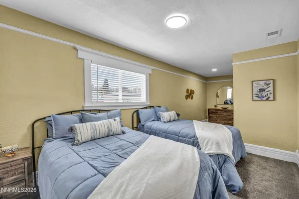 a bathroom with a granite countertop sink vanity mirror and toilet