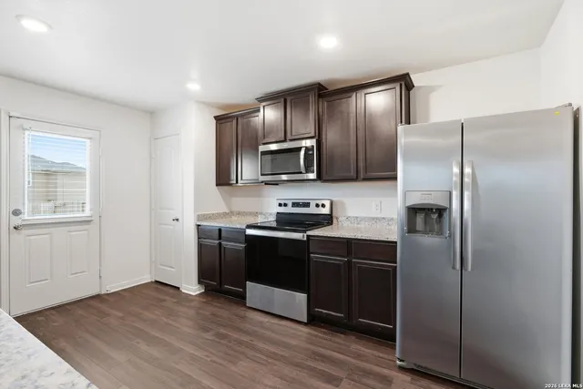 a kitchen with stainless steel appliances granite countertop a refrigerator stove and sink