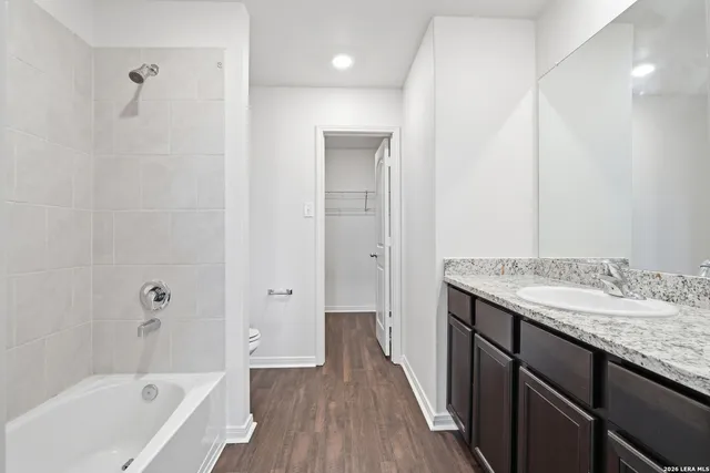 a bathroom with a granite countertop sink a toilet and shower