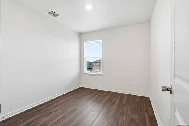 a view of a room with wooden floor and window
