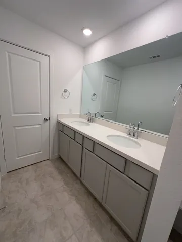 a bathroom with a double vanity sink and mirror