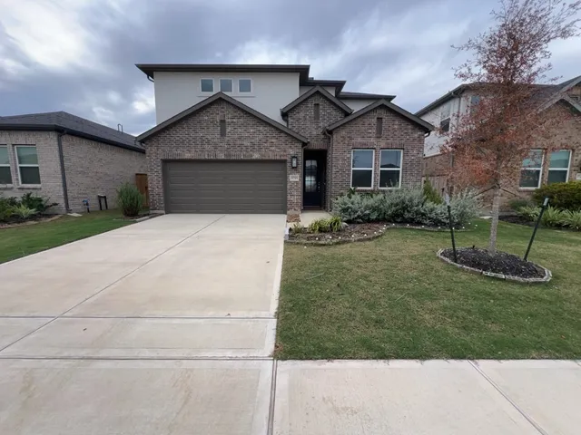 a front view of a house with a yard and garage