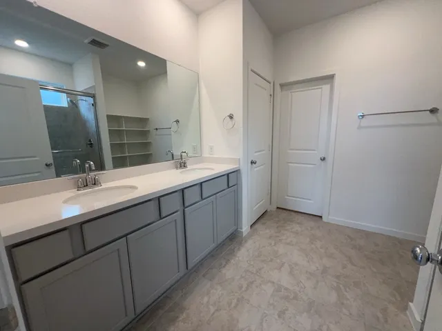 a bathroom with a double vanity sink and mirror