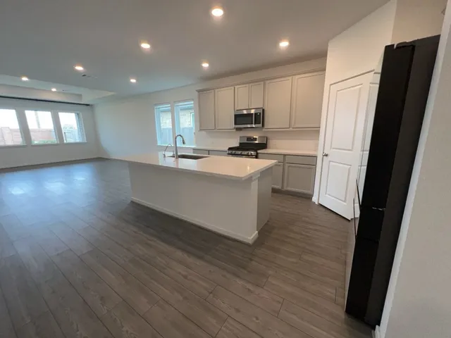 a kitchen with stainless steel appliances a refrigerator a sink dishwasher and a stove top oven