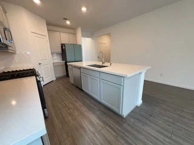 a kitchen with a sink refrigerator and microwave