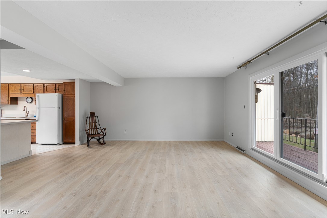 6462 State Road, Unit 4 Parma, OH 44134 - Photo 7 of 42 Unfurnished living room featuring baseboards, light wood-style floors, visible vents, and a sink