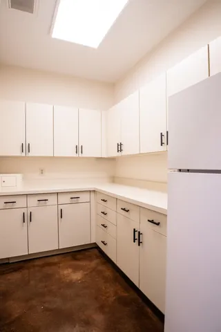 a kitchen with granite countertop white cabinets and white appliances