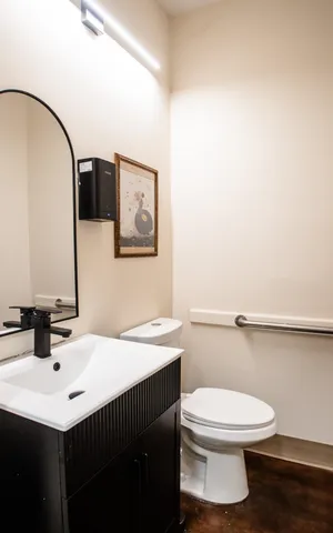 a bathroom with a sink toilet and mirror