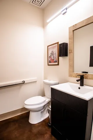 a bathroom with a sink mirror vanity and toilet