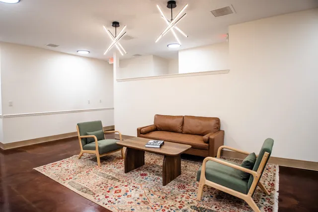 a living room with furniture a rug and a ceiling fan
