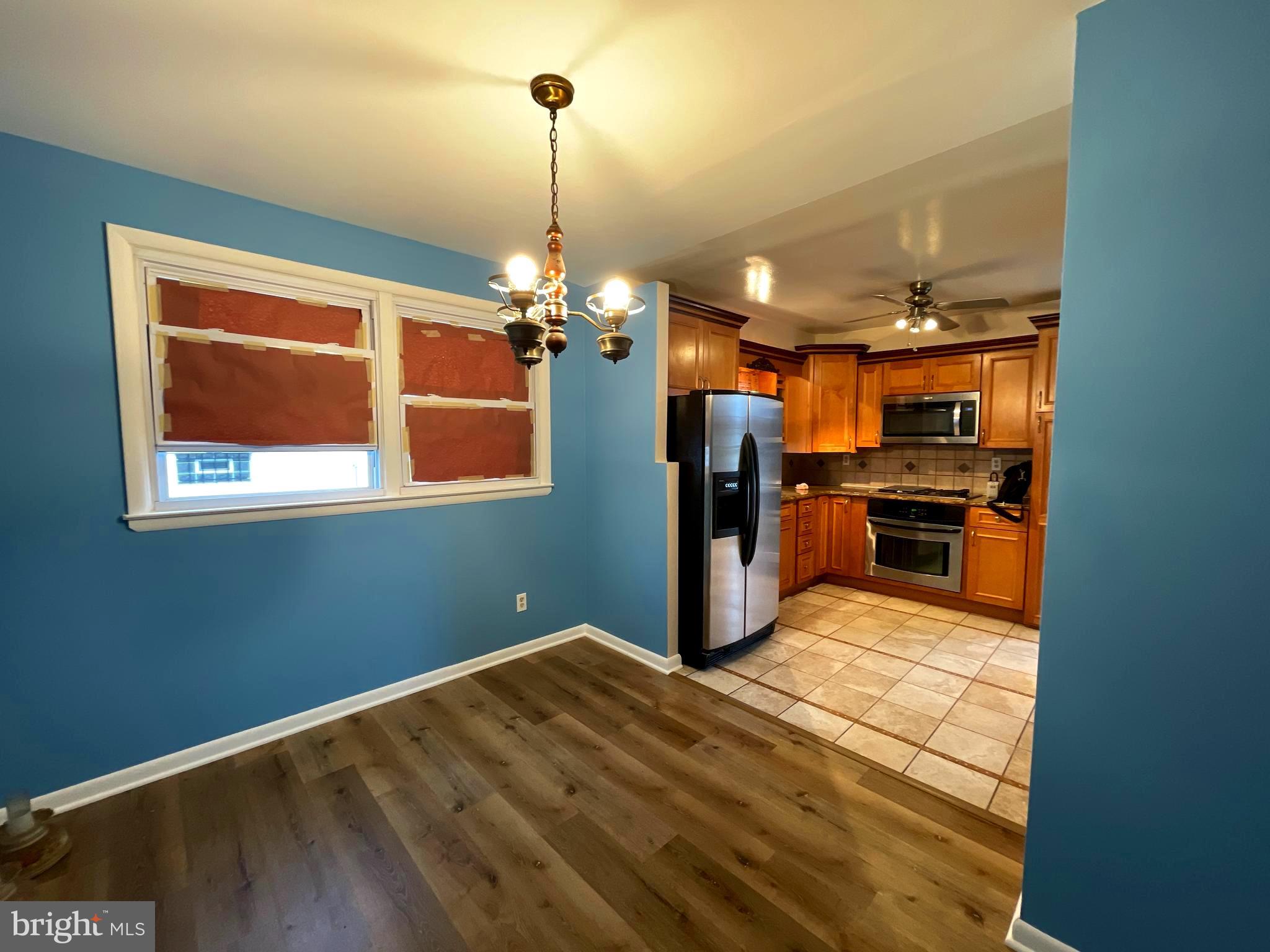 6804 Lenbern Road Baltimore, MD 21207 - Photo 2 of 17 a kitchen with stainless steel appliances kitchen island granite countertop a refrigerator and a stove top oven