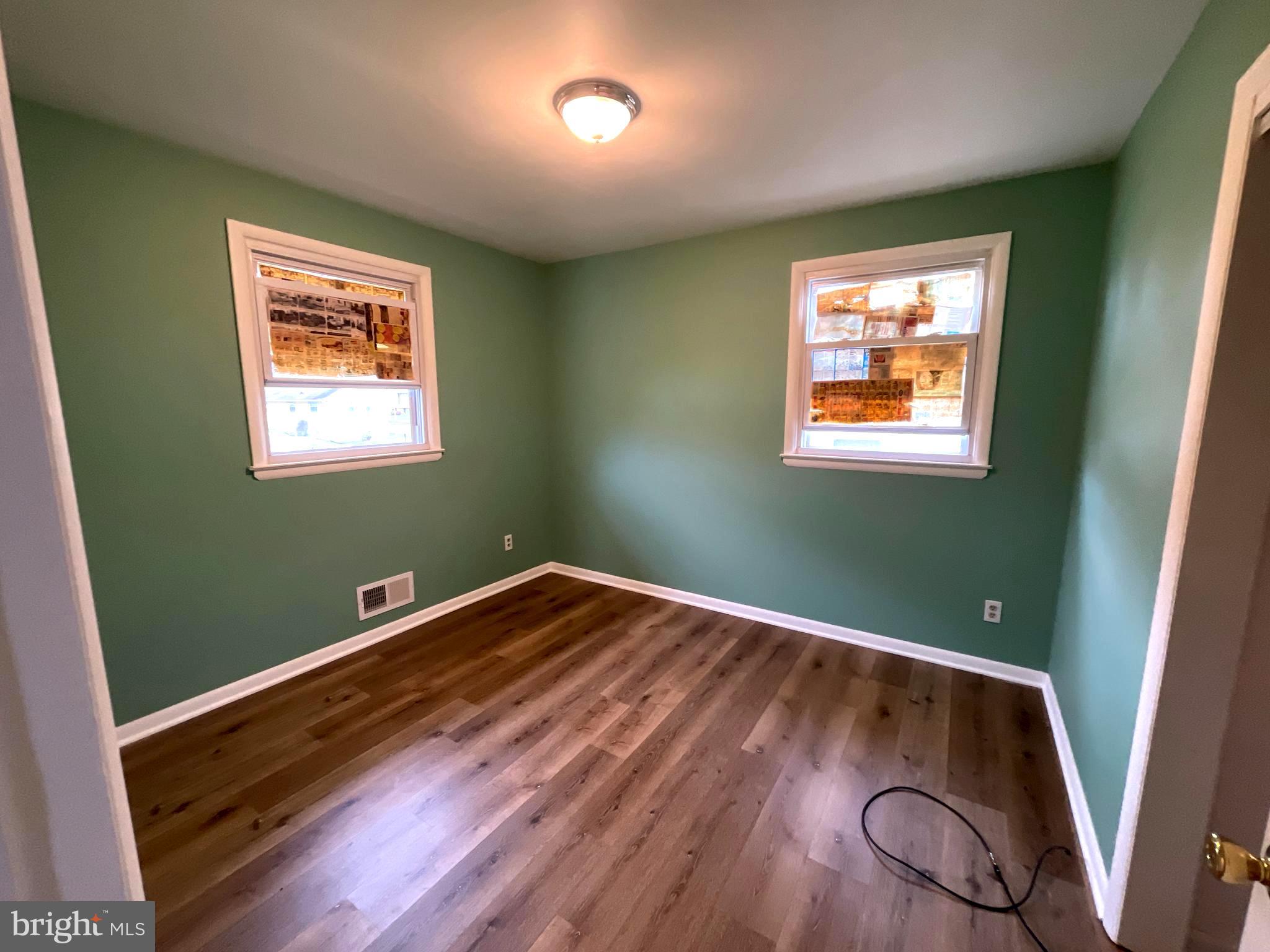 6804 Lenbern Road Baltimore, MD 21207 - Photo 8 of 17 a view of room with window and wooden floor
