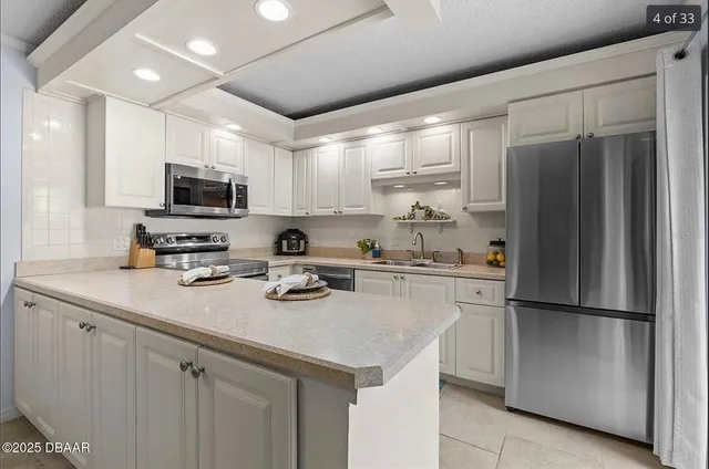 a kitchen with a sink a center island stainless steel appliances and cabinets