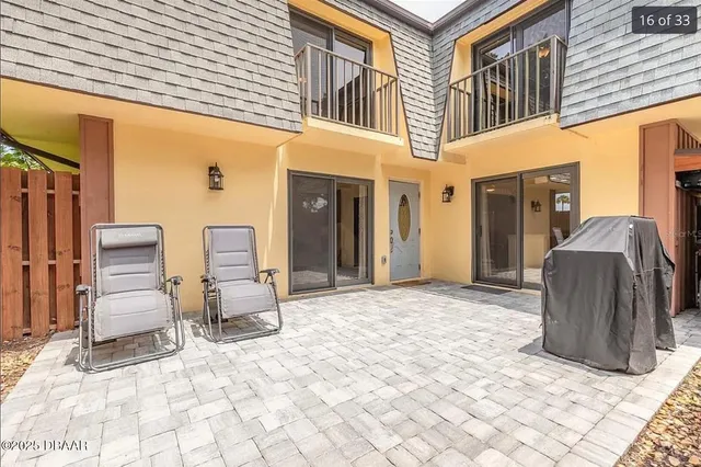 a view of a patio with a table and chairs and barbeque