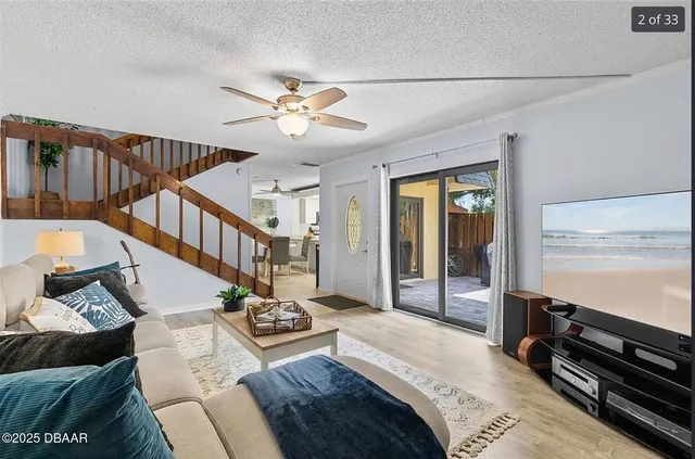 a living room with couches a dining table and chairs with wooden floor