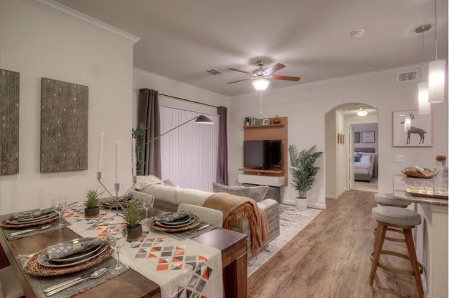 a living room with furniture a flat screen tv and kitchen view
