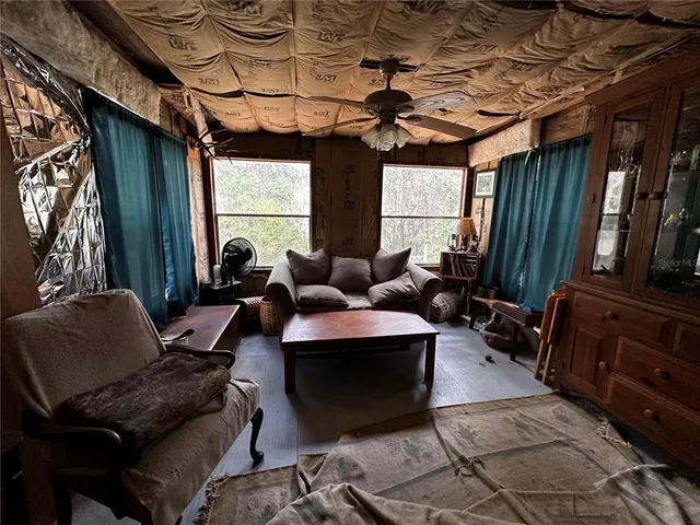 a living room with furniture a flat screen tv and a window