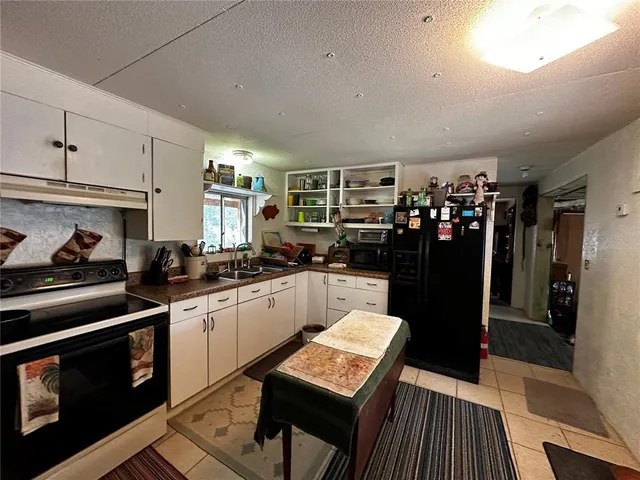 a kitchen with a refrigerator and a stove top oven