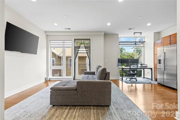 a living room with furniture wooden floor and a flat screen tv