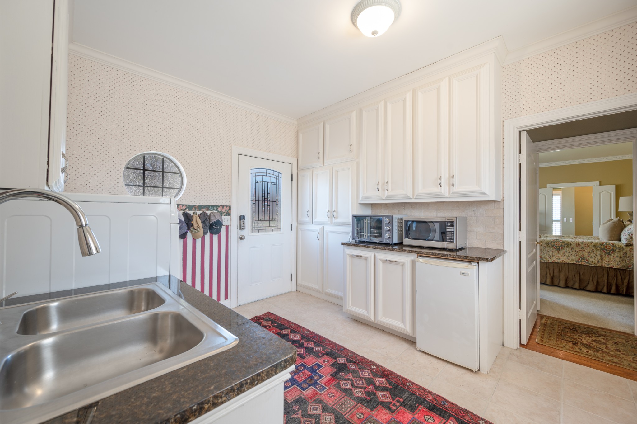 4335 North Chapel Road Franklin, TN 37067 - Photo 50 of 55 a kitchen with a sink dishwasher a stove and white cabinets with wooden floor