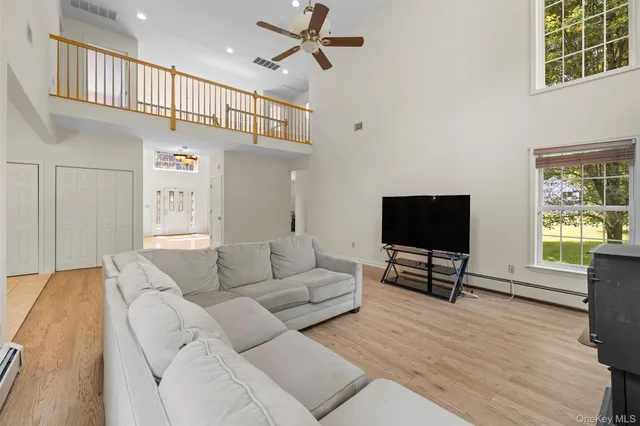 a living room with furniture a window and a flat screen tv