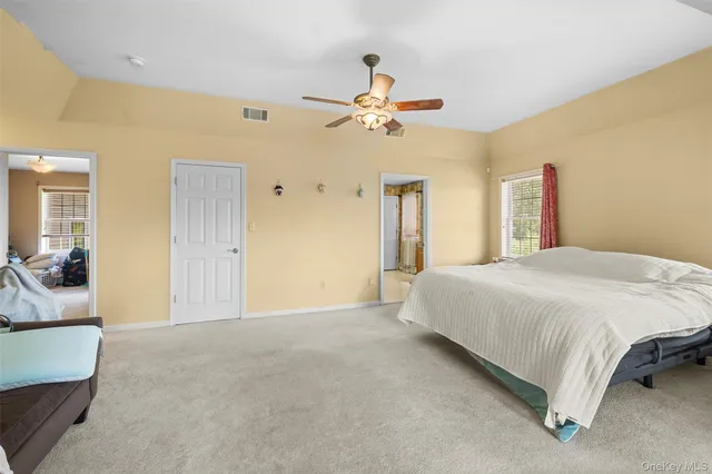 a spacious bedroom with a bed and a chandelier