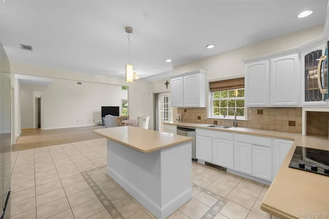 a large white kitchen with a sink and cabinets