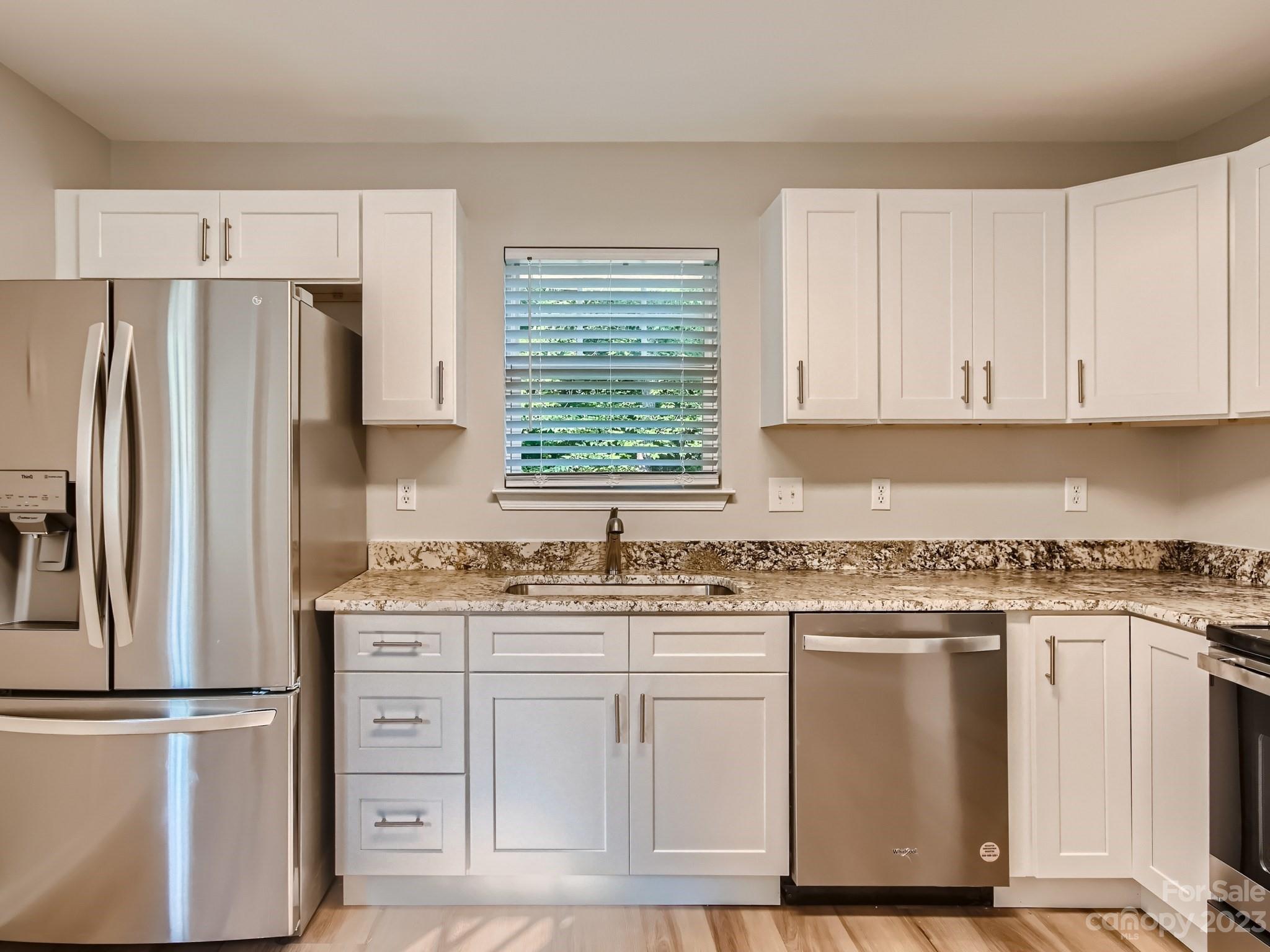 6608 Love Ridge Lane Charlotte, NC 28213 - Photo 12 of 28 a kitchen with white cabinets white stainless steel appliances and sink