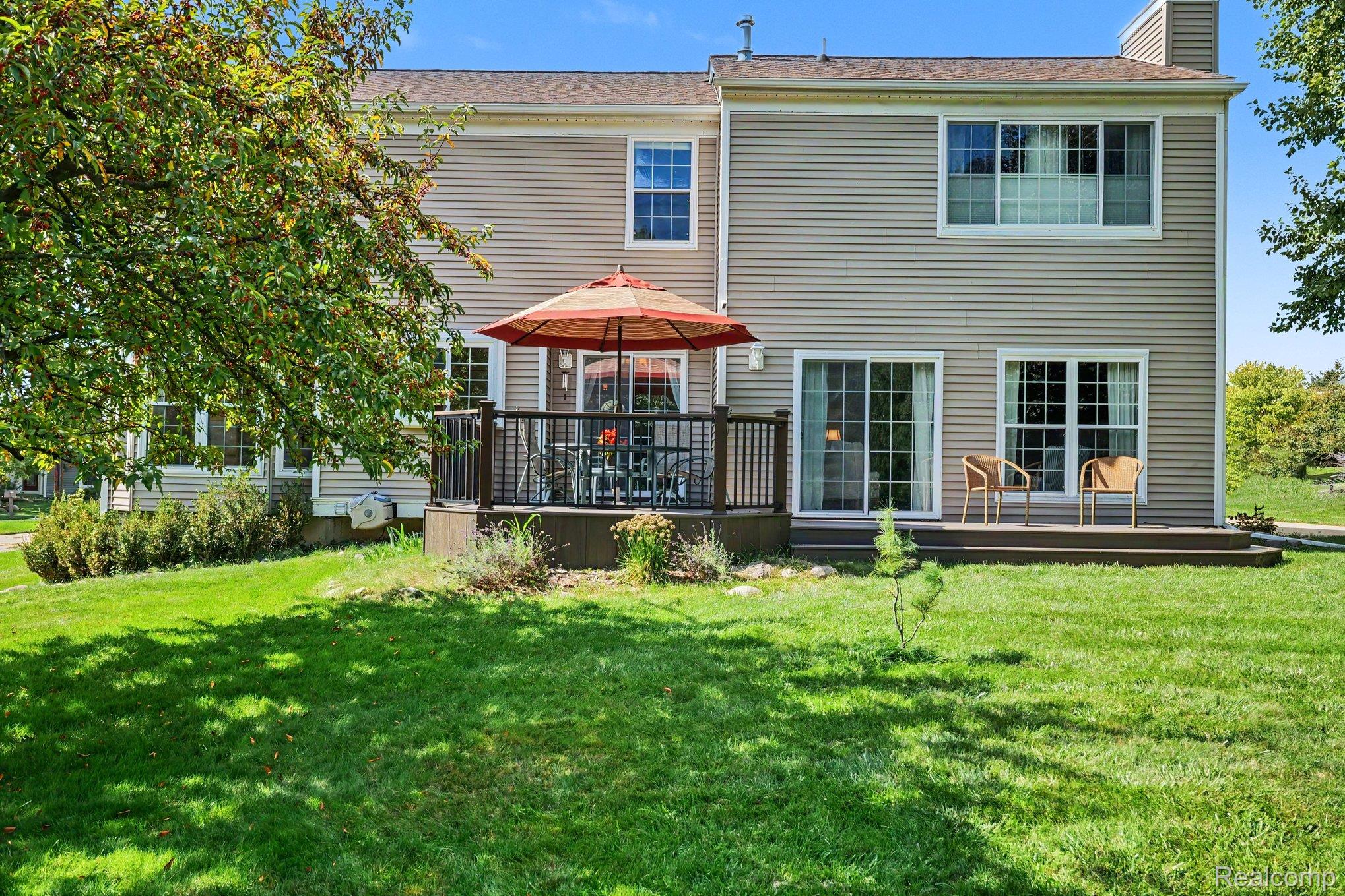 1692 Ridgecrest Rochester, MI 48306 - Photo 24 of 31 Spacious backyard featuring a multi-level deck, sliding glass doors, and a manicured lawn