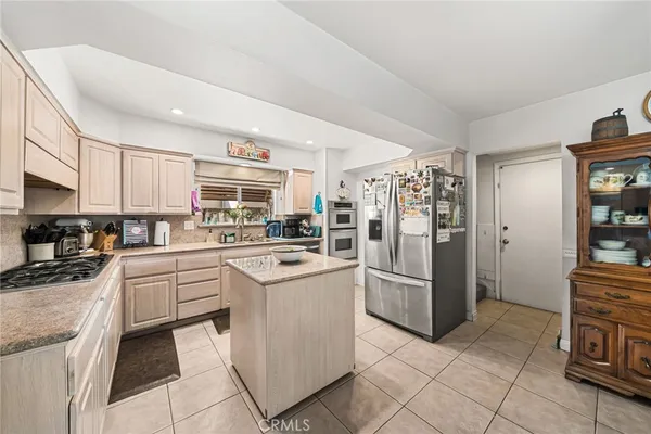 a kitchen with stainless steel appliances granite countertop a refrigerator and a stove top oven