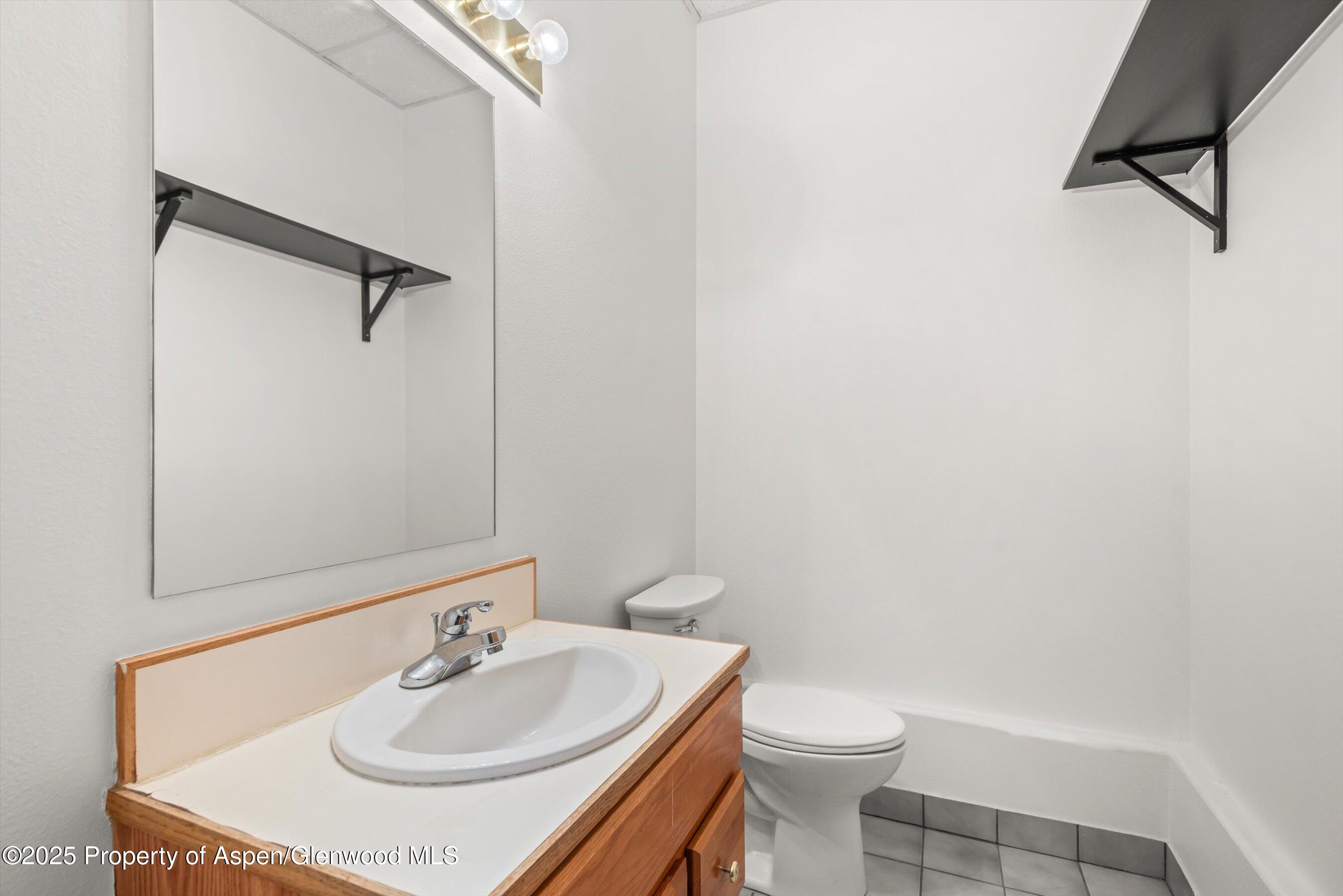 207 Basalt Center Circle, Unit 104 Basalt, CO 81621 - Photo 13 of 13 a bathroom with a sink toilet and a mirror