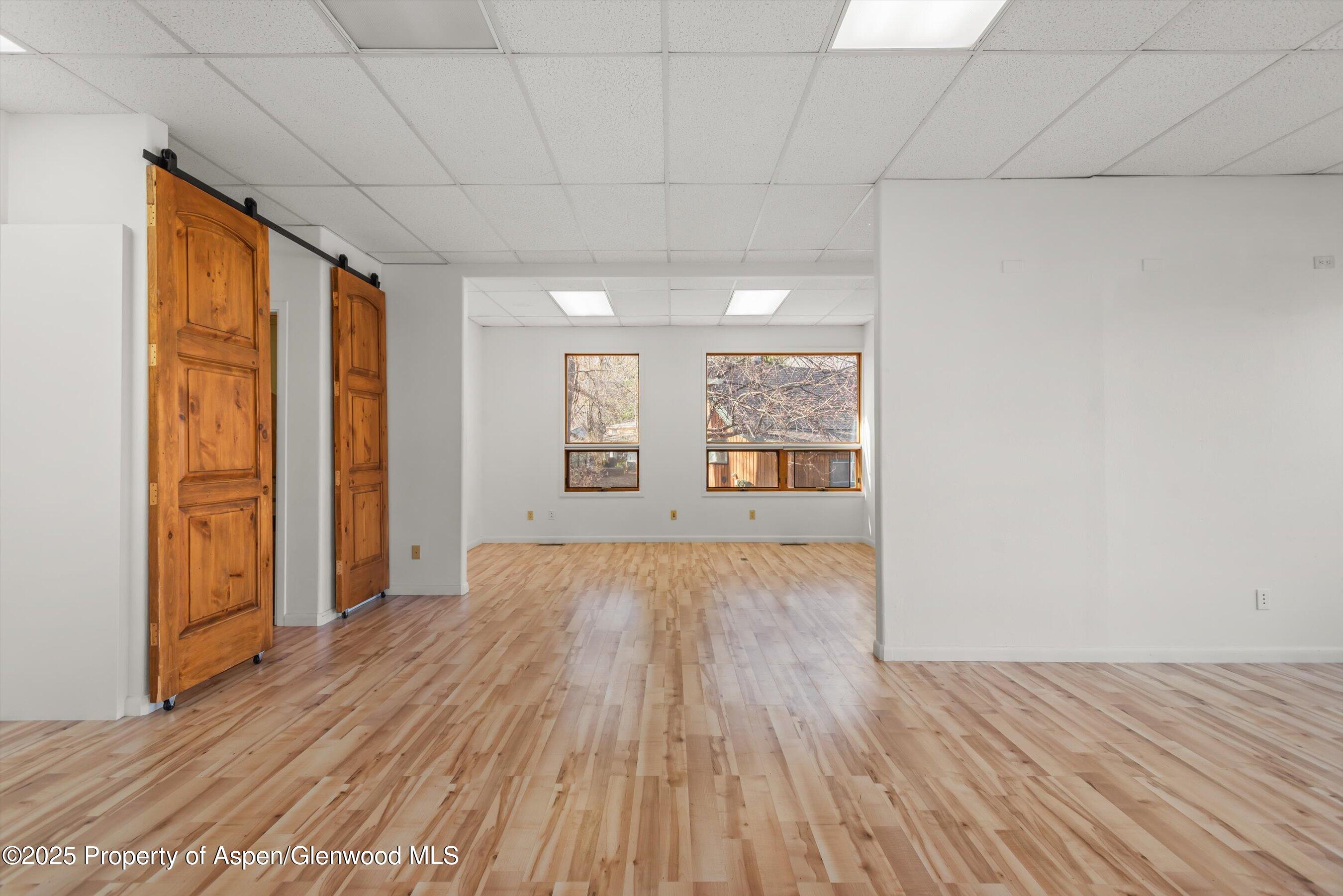 207 Basalt Center Circle, Unit 104 Basalt, CO 81621 - Photo 4 of 13 an empty room with wooden floor and windows