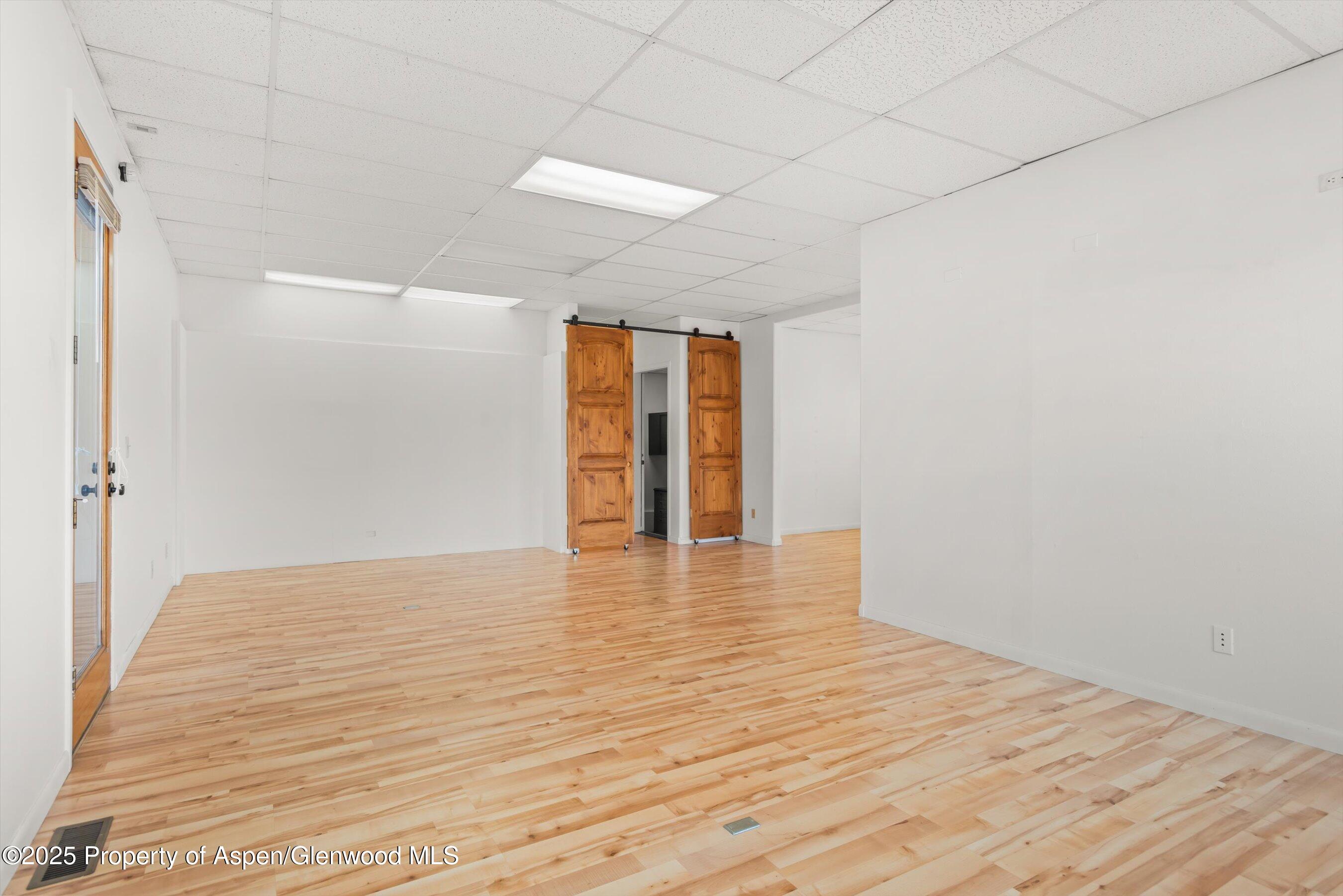 207 Basalt Center Circle, Unit 104 Basalt, CO 81621 - Photo 6 of 13 a view of an empty room with wooden floor and a window
