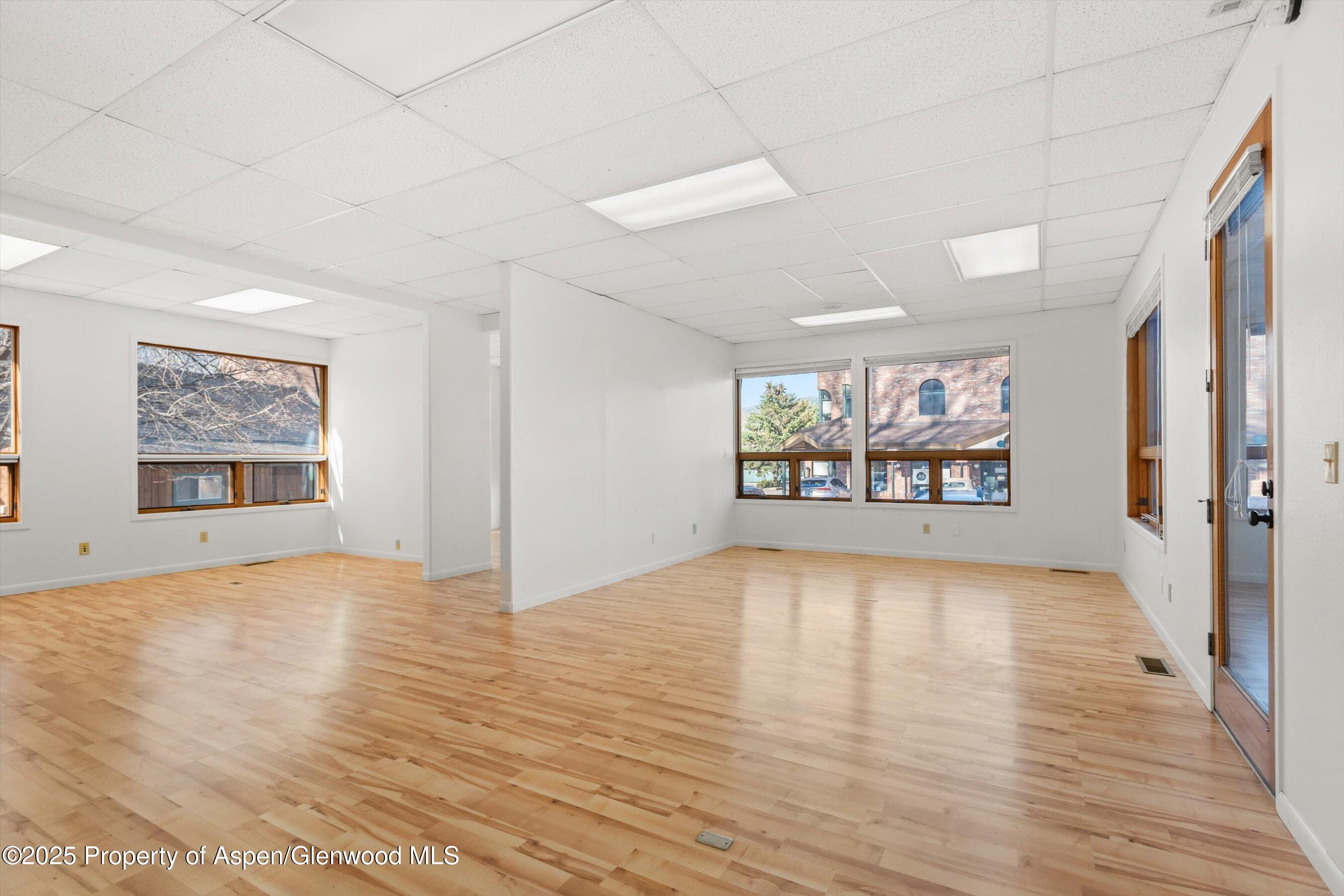 207 Basalt Center Circle, Unit 104 Basalt, CO 81621 - Photo 9 of 13 a view of an empty room with window and wooden floor