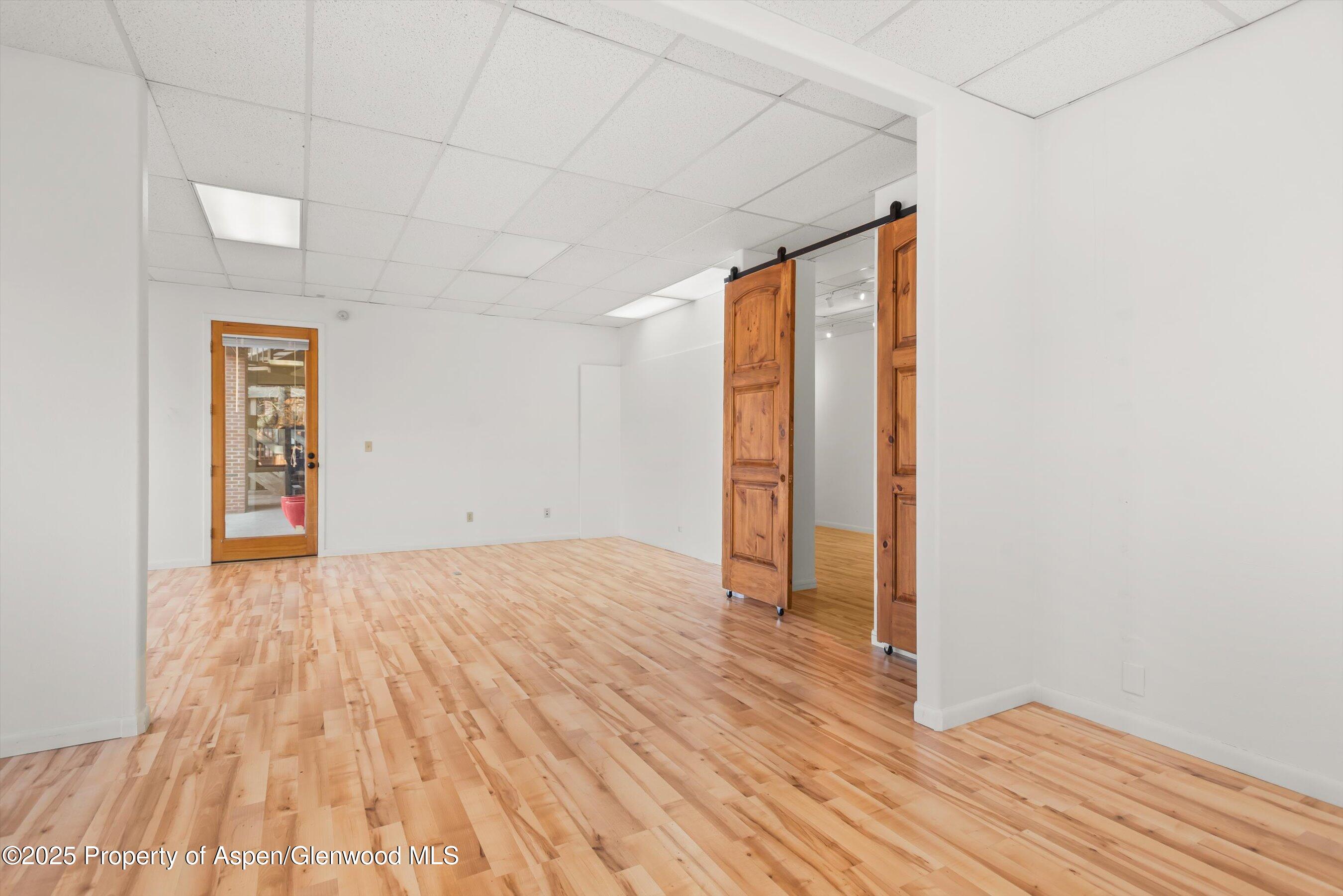 207 Basalt Center Circle, Unit 104 Basalt, CO 81621 - Photo 10 of 13 an empty room with wooden floor and windows