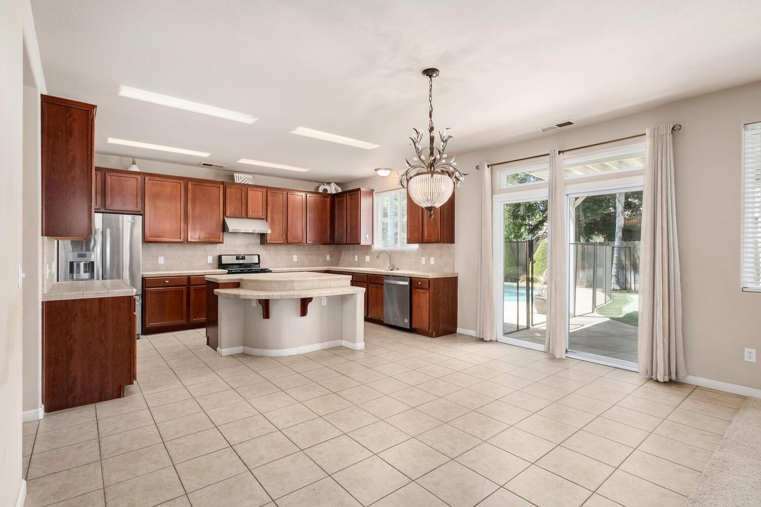 1182 Carson Avenue Clovis, CA 93611 - Photo 12 of 38 a kitchen with stainless steel appliances granite countertop a stove top oven a sink a counter space and cabinets