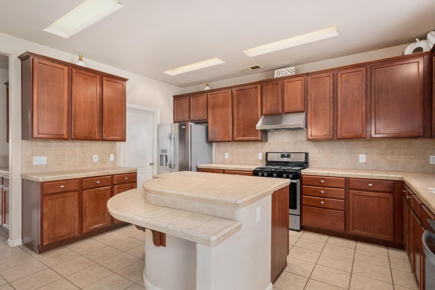 1182 Carson Avenue Clovis, CA 93611 - Photo 13 of 38 a kitchen with stainless steel appliances granite countertop a sink stove refrigerator and cabinets