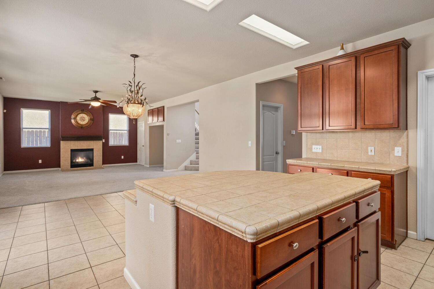 1182 Carson Avenue Clovis, CA 93611 - Photo 16 of 38 a kitchen with a wooden cabinets and chandelier