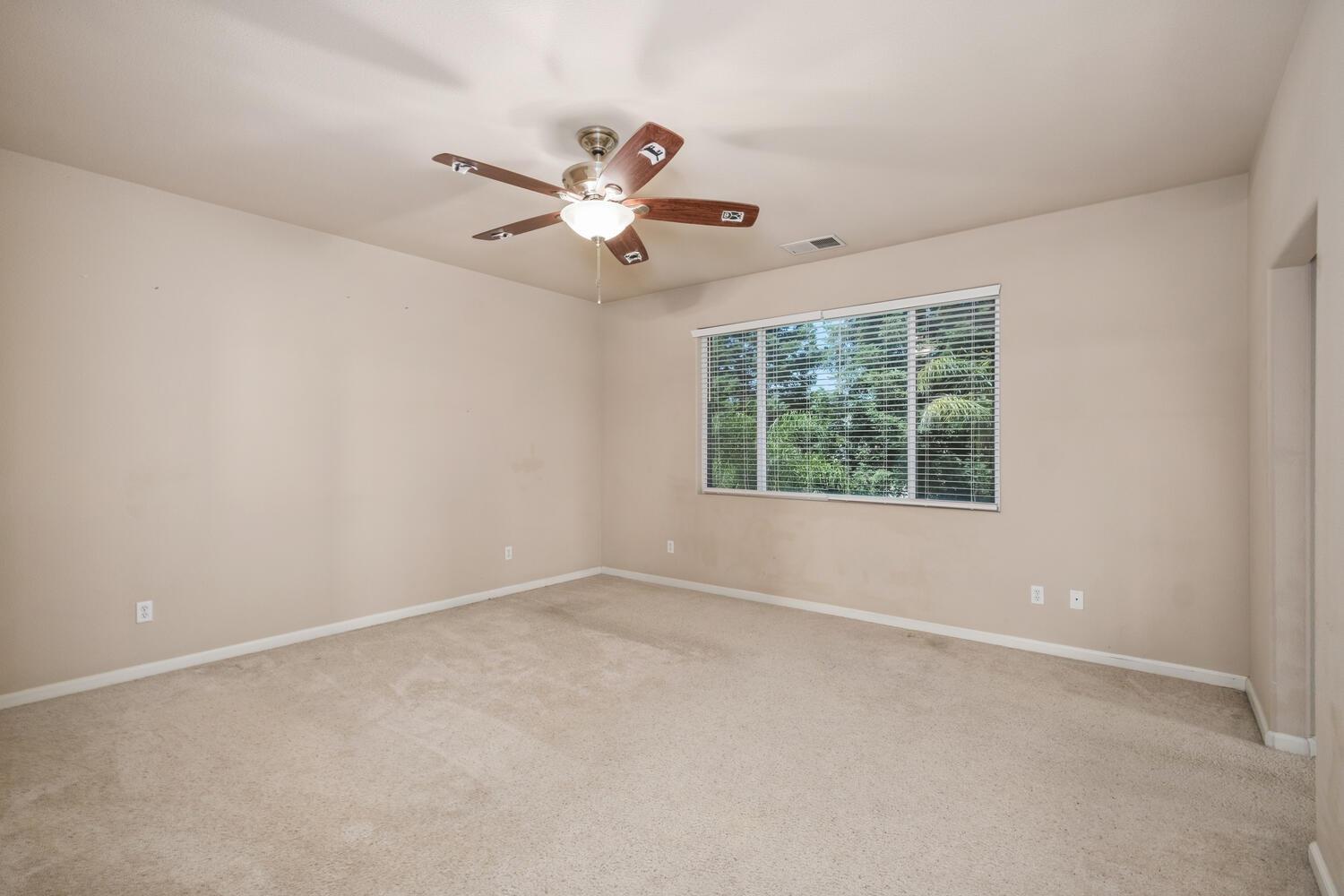 1182 Carson Avenue Clovis, CA 93611 - Photo 22 of 38 an empty room with a window and a fan