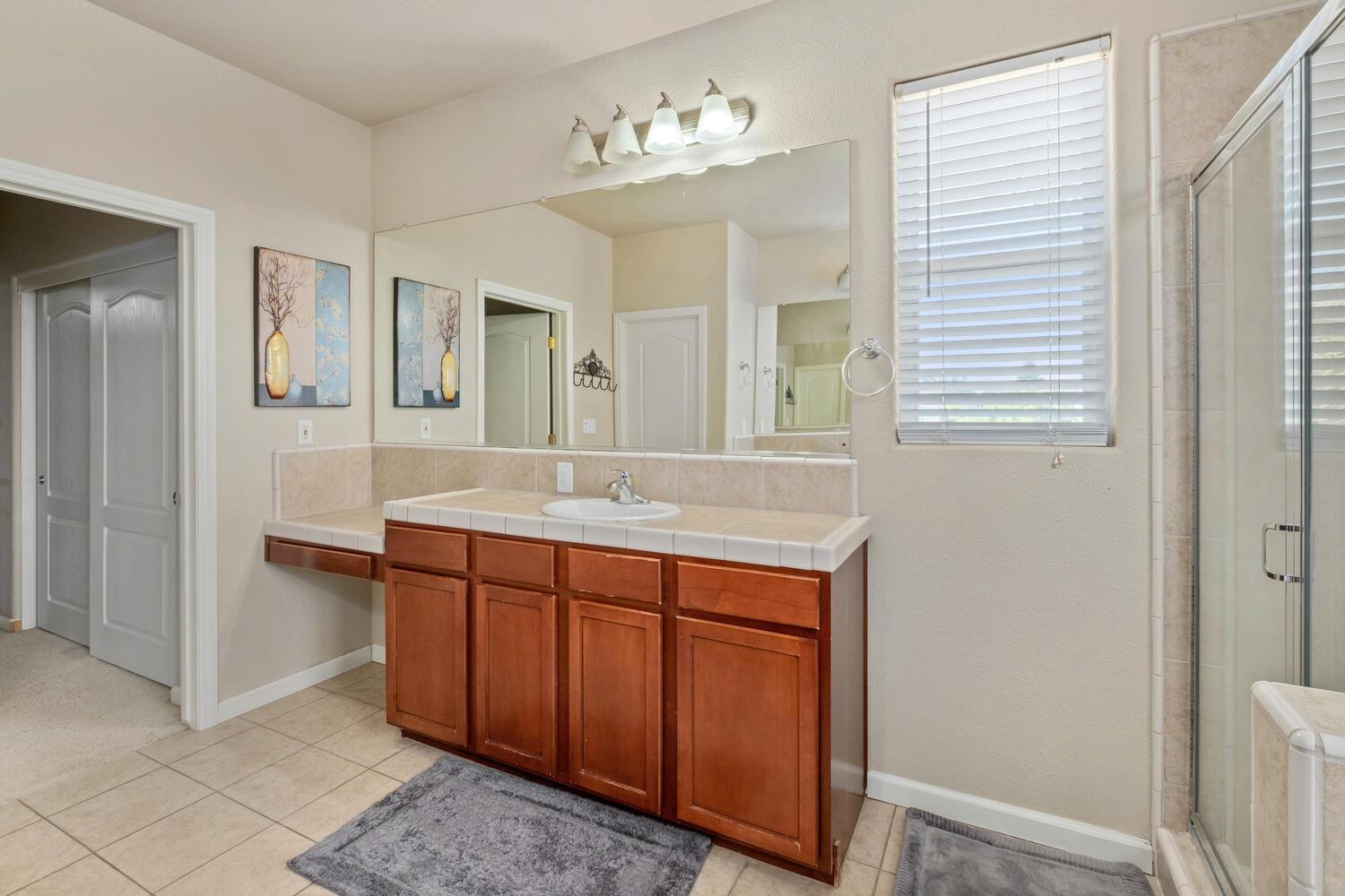 1182 Carson Avenue Clovis, CA 93611 - Photo 23 of 38 a spacious bathroom with a double vanity sink and a mirror