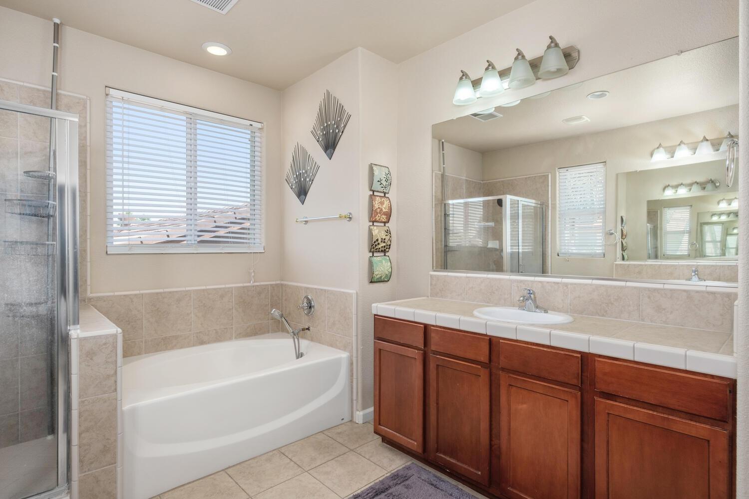 1182 Carson Avenue Clovis, CA 93611 - Photo 25 of 38 a bathroom with a tub sink and mirror