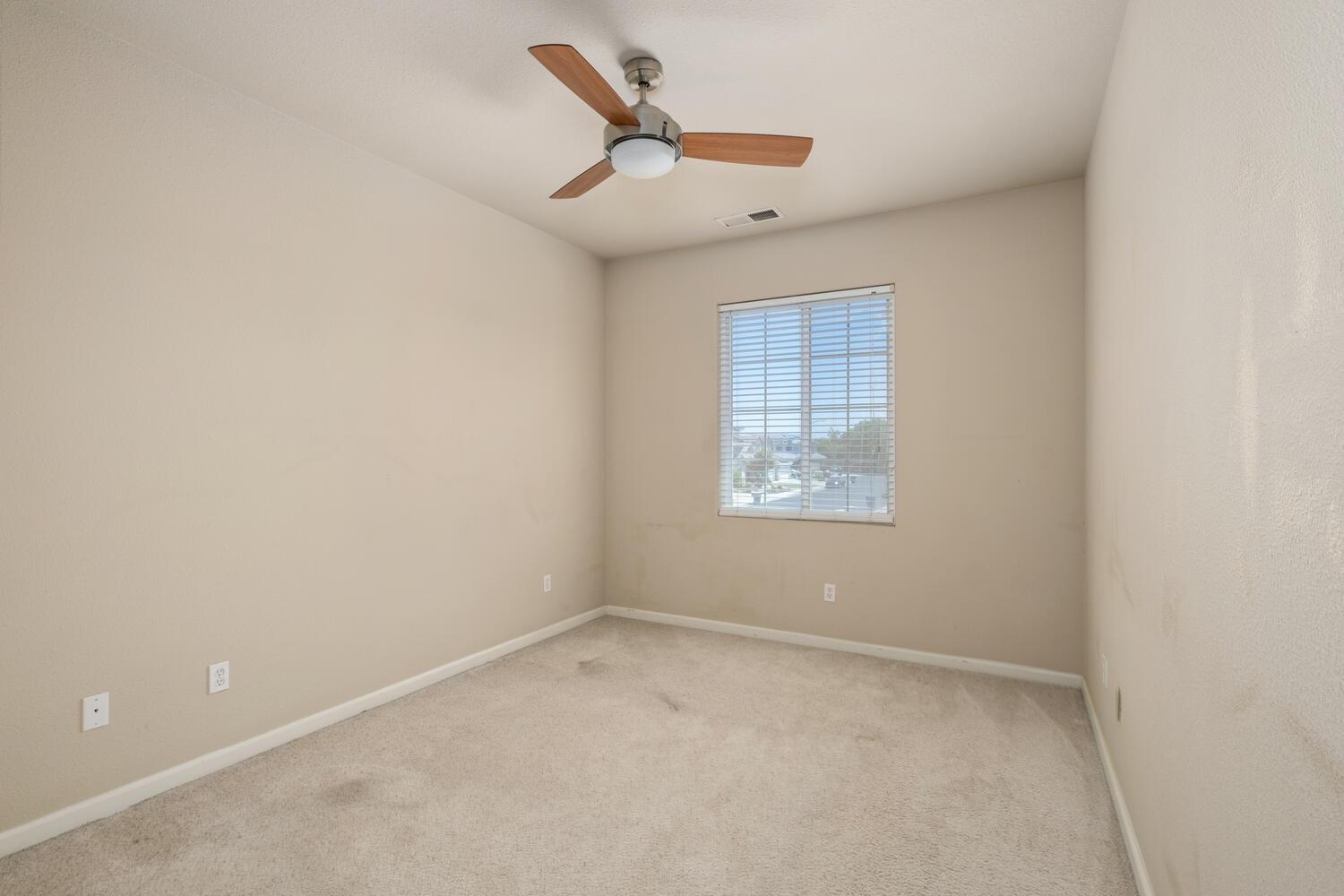 1182 Carson Avenue Clovis, CA 93611 - Photo 30 of 38 an empty room with a ceiling fan and windows