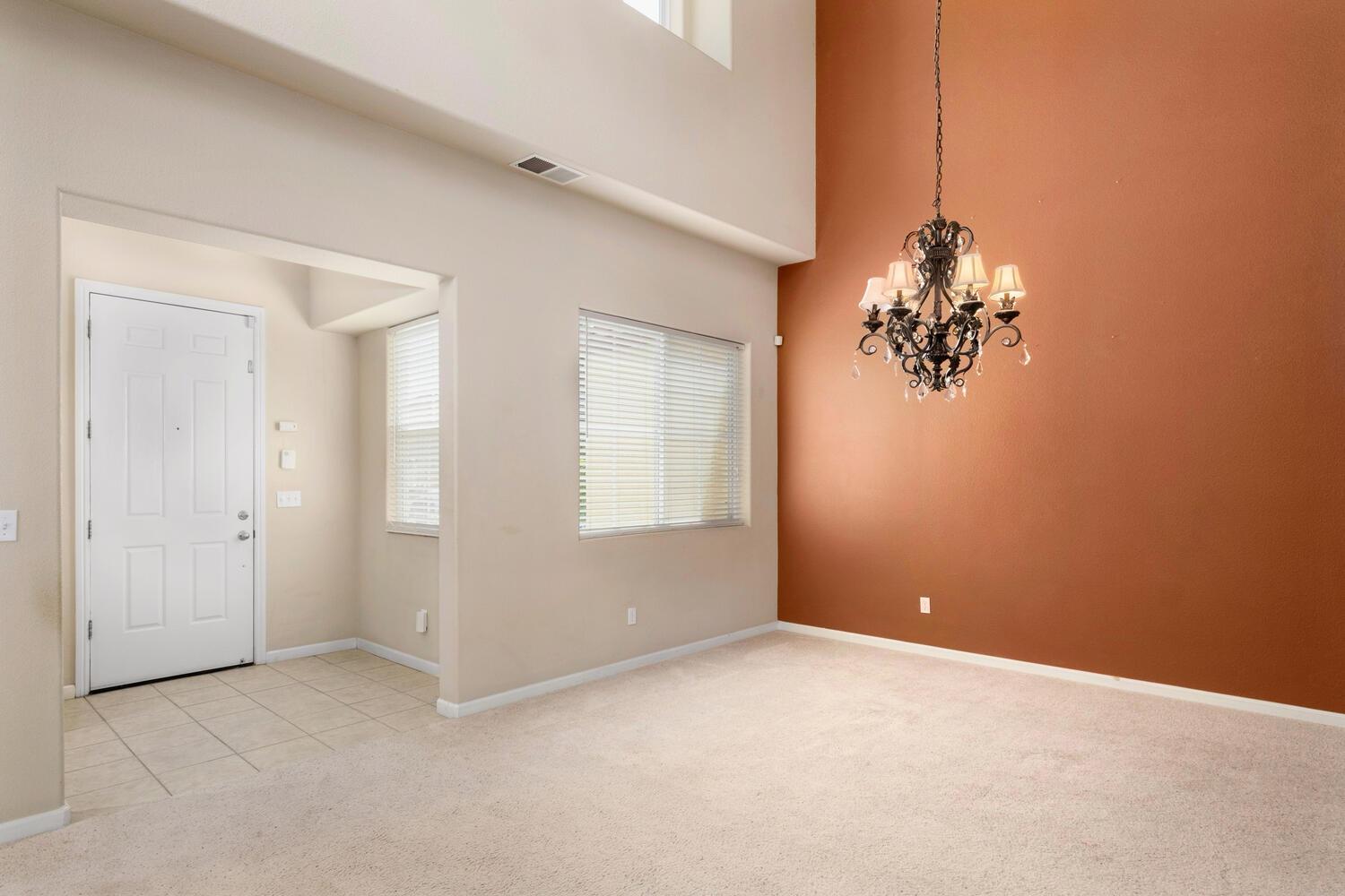 1182 Carson Avenue Clovis, CA 93611 - Photo 7 of 38 an empty room with windows and chandelier fan