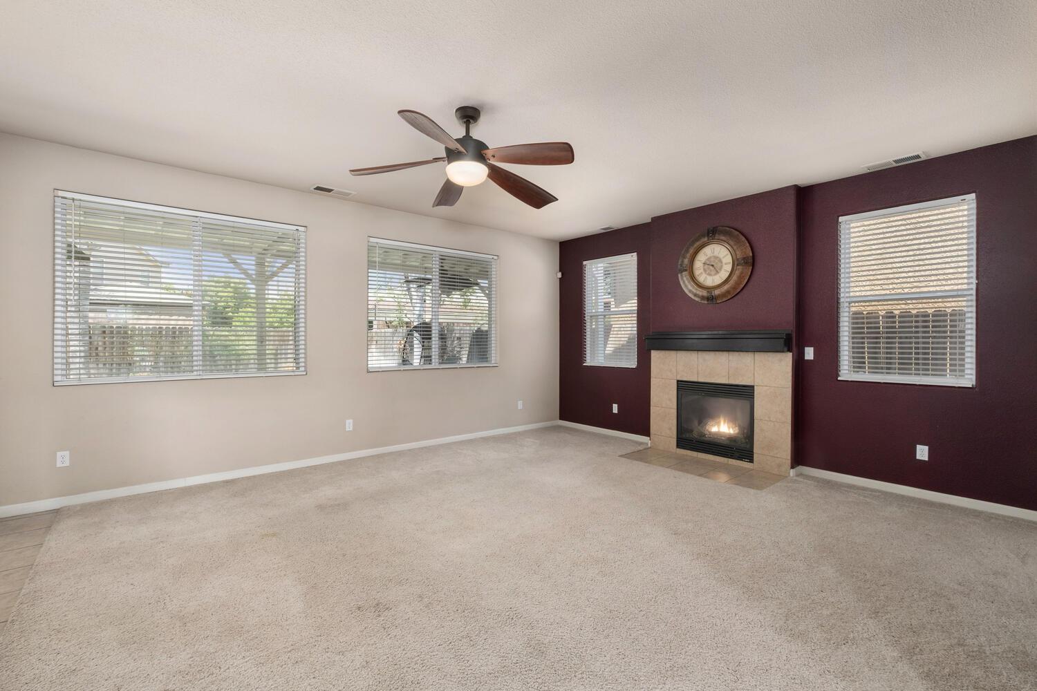 1182 Carson Avenue Clovis, CA 93611 - Photo 10 of 38 an empty room with windows and fireplace