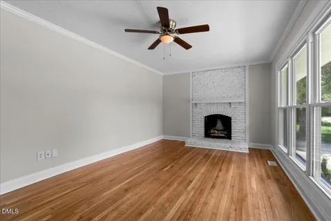 a view of a livingroom with wooden floor a fireplace