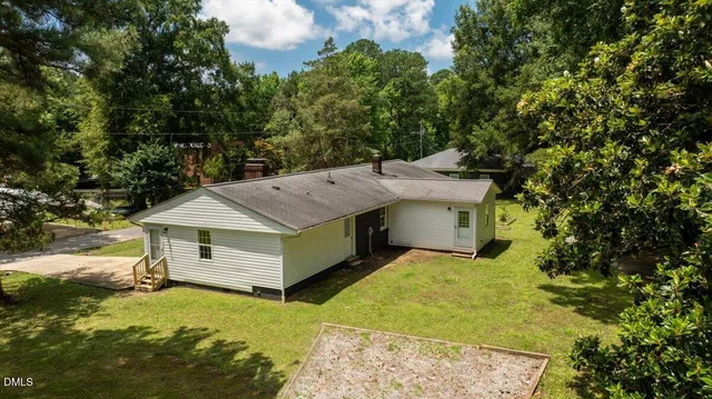 a view of a house with a yard and large tree