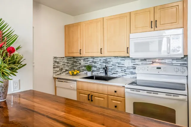 a kitchen with granite countertop white cabinets and white appliances