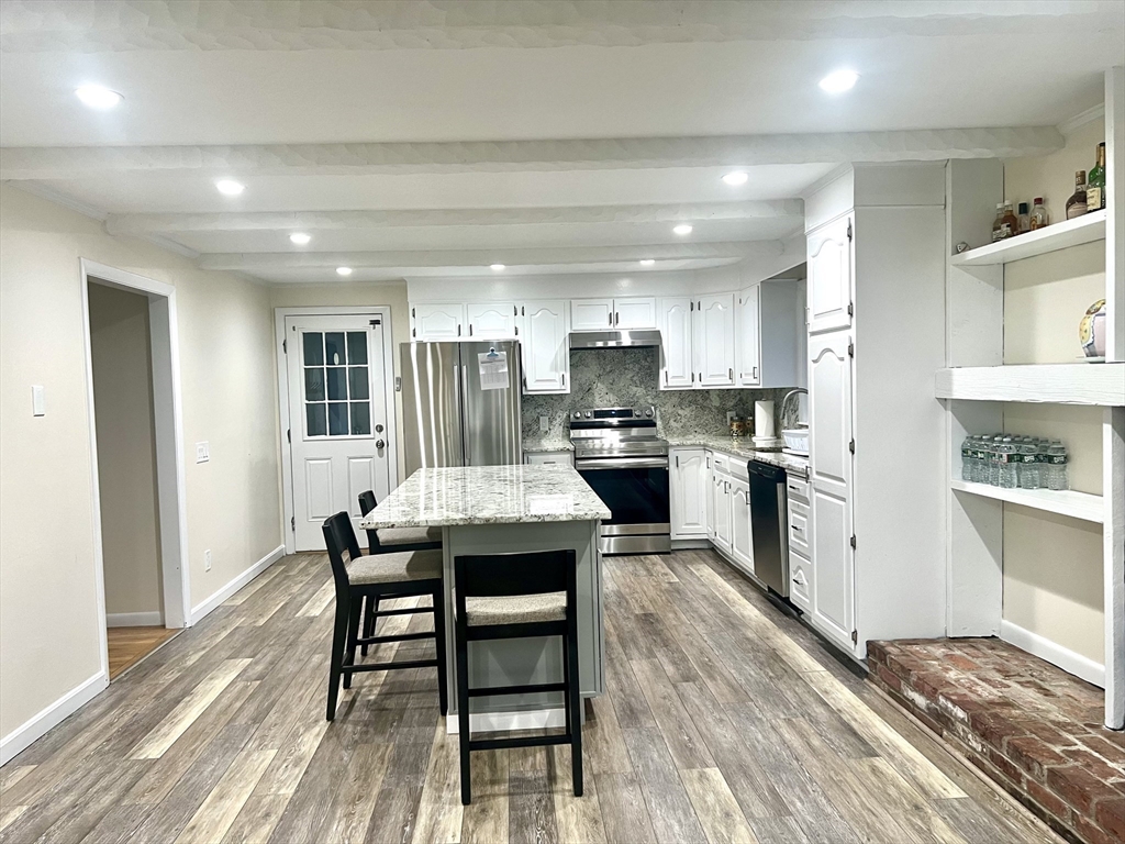 50 Main Street Medway, MA 02053 - Photo 3 of 23 a kitchen with stainless steel appliances granite countertop a stove top oven a sink dishwasher and cabinets with wooden floor