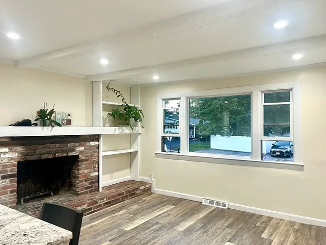 a living room with a fireplace windows and a fireplace